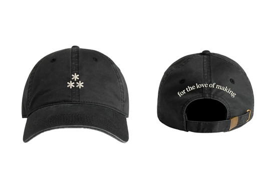 Two black baseball caps with text and an asterism logo